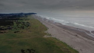 4K aerial stock footage of a reverse view of groups of beach-goers near the ocean in Long Beach, Washington Aerial Stock Footage | DX0002_148_023