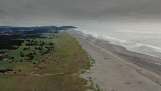 DX0002_148_030 - 4K aerial stock footage of the beach, ocean waves, and fireworks at sunset in Long Beach, Washington