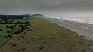 4K aerial stock footage approach the beach as fireworks go off at sunset in Long Beach, Washington Aerial Stock Footage | DX0002_148_032