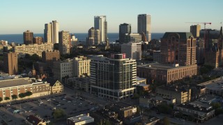 DX0002_150_016 - 5.7K aerial stock footage passing dormitory building for view of the city's skyline at sunset, Downtown Milwaukee, Wisconsin