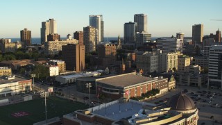 5.7K aerial stock footage of away from the skyline, descend near college campus at sunset in Downtown Milwaukee, Wisconsin Aerial Stock Footage | DX0002_150_019