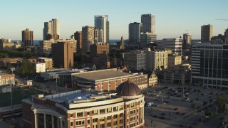 DX0002_150_020 - 5.7K aerial stock footage fly over college campus at sunset to approach city skyline, Downtown Milwaukee, Wisconsin