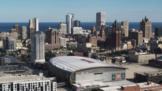 DX0002_152_031 - 5.7K aerial stock footage the city's skyline while ascending by arena in Downtown Milwaukee, Wisconsin