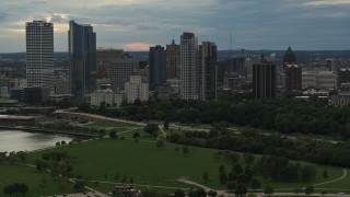 5.7K aerial stock footage of the city's skyline seen from green park at sunset, Downtown Milwaukee, Wisconsin Aerial Stock Footage | DX0002_155_012