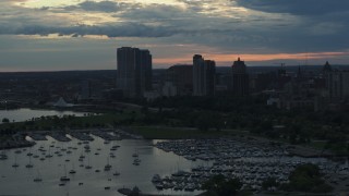 5.7K aerial stock footage of skyscrapers in the city's skyline seen while ascending past the marina at sunset, Downtown Milwaukee, Wisconsin Aerial Stock Footage | DX0002_155_021