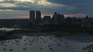 5.7K aerial stock footage of skyscrapers in the city's skyline seen while descending past the marina at sunset, Downtown Milwaukee, Wisconsin Aerial Stock Footage | DX0002_155_022