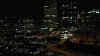 5.7K aerial stock footage ascend and fly away from the base of a towering skyscraper at night, Downtown Milwaukee, Wisconsin Aerial Stock Footage | DX0002_157_037