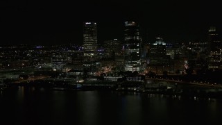 DX0002_157_039 - 5.7K aerial stock footage a pair of towering skyscrapers seen from the lake at night, Downtown Milwaukee, Wisconsin