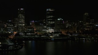 DX0002_157_042 - 5.7K aerial stock footage of a towering skyscraper seen from Lake Michigan at night, Downtown Milwaukee, Wisconsin