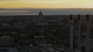 5.7K aerial stock footage focus on the capitol dome at sunset while passing smoke stacks, Madison, Wisconsin Aerial Stock Footage | DX0002_161_027