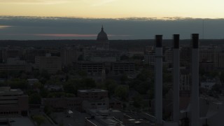 5.7K aerial stock footage flyby smoke stacks to approach the capitol dome at sunset, Madison, Wisconsin Aerial Stock Footage | DX0002_162_004