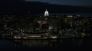 DX0002_162_030 - 5.7K aerial stock footage focus on capitol dome while passing the convention center at night, Madison, Wisconsin