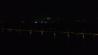 DX0002_162_055 - 5.7K aerial stock footage of panning across a causeway on the lake at night, Madison, Wisconsin