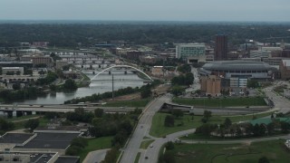 DX0002_167_012 - 5.7K aerial stock footage of passing by bridges over Cedar River by the arena in Downtown Des Moines, Iowa