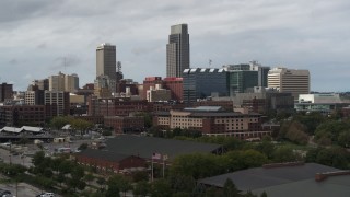 5.7K aerial stock footage descend with view of a towering skyscraper and downtown skyline in Downtown Omaha, Nebraska Aerial Stock Footage | DX0002_168_013