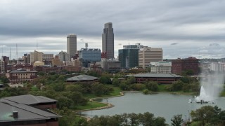 DX0002_169_024 - 5.7K aerial stock footage reverse view of a fountain in a park and skyline, Downtown Omaha, Nebraska