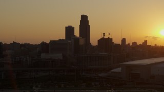 5.7K aerial stock footage a reverse view of skyscraper and skyline with setting sun in background, Downtown Omaha, Nebraska Aerial Stock Footage | DX0002_172_024