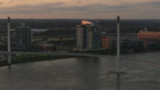 DX0002_172_028 - 5.7K aerial stock footage orbit condo complex behind a pedestrian bridge spanning the Missouri River at sunset, Omaha, Nebraska