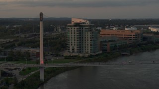 DX0002_172_029 - 5.7K aerial stock footage of a condo complex near a pedestrian bridge spanning the Missouri River at sunset, Omaha, Nebraska