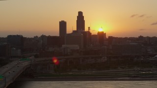 DX0002_172_032 - 5.7K aerial stock footage slowly circle the skyline, setting sun in background, Downtown Omaha, Nebraska