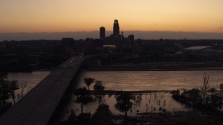 5.7K aerial stock footage flyby and approach the skyline and a bridge over the river at twilight, Downtown Omaha, Nebraska Aerial Stock Footage | DX0002_172_043