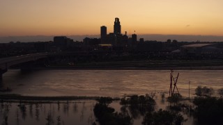 5.7K aerial stock footage a view of the skyline while descending by the river at twilight, Downtown Omaha, Nebraska Aerial Stock Footage | DX0002_172_044