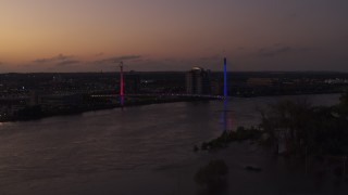 DX0002_172_050 - 5.7K aerial stock footage of flying away from a pedestrian bridge spanning the Missouri River at twilight, Omaha, Nebraska