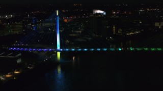 DX0002_173_021 - 5.7K aerial stock footage of orbiting the end of a pedestrian bridge spanning the Missouri River at night, Omaha, Nebraska