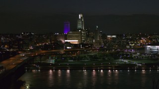 5.7K aerial stock footage of the city's skyline at night, seen while flying over river, Downtown Omaha, Nebraska Aerial Stock Footage | DX0002_173_033