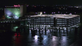 DX0002_173_045 - 5.7K aerial stock footage orbit a parking garage and reveal the hotel and casino at night in Council Bluffs, Iowa