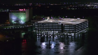 DX0002_173_046 - 5.7K aerial stock footage orbit and fly away from parking garage and the hotel and casino at night in Council Bluffs, Iowa