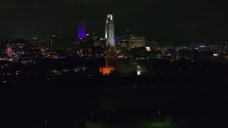 5.7K aerial stock footage of towering skyscrapers behind the fountain lit up at night, Downtown Omaha, Nebraska Aerial Stock Footage | DX0002_173_053