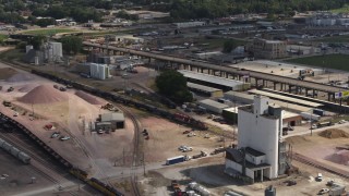 DX0002_175_031 - 5.7K aerial stock footage of a train passing warehouse and industrial buildings in Sioux City, Iowa