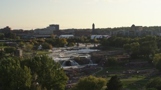 DX0002_176_006 - 5.7K aerial stock footage ascend and reveal the waterfalls at Falls Park at sunset in Sioux Falls, South Dakota