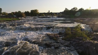 DX0002_176_013 - 5.7K aerial stock footage fly over the waterfalls at sunset in Sioux Falls, South Dakota