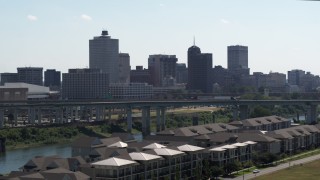 5.7K aerial stock footage ascend from trees for view of the city's skyline and bridge in Downtown Memphis, Tennessee Aerial Stock Footage | DX0002_177_005