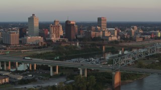 5.7K aerial stock footage flyby the city's skyline behind the bridge and the river at sunset, Downtown Memphis, Tennessee Aerial Stock Footage | DX0002_181_014