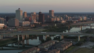 DX0002_181_015 - 5.7K aerial stock footage a view of the city's skyline behind the bridge and the river at sunset, Downtown Memphis, Tennessee