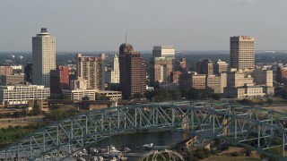 5.7K aerial stock footage of the skyline seen while descending behind the bridge at sunset, Downtown Memphis, Tennessee Aerial Stock Footage | DX0002_185_024