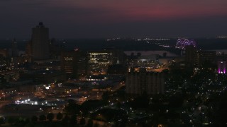 DX0002_187_026 - 5.7K aerial stock footage city buildings between office tower and bridge at night, Downtown Memphis, Tennessee