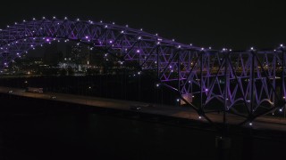 5.7K aerial stock footage of passing the bridge with purple lights and a view of the skyline at night, Downtown Memphis, Tennessee Aerial Stock Footage | DX0002_187_036