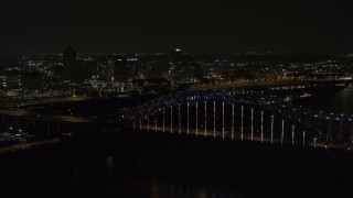 5.7K aerial stock footage of the skyline seen while passing the bridge with colorful lights at night, Downtown Memphis, Tennessee Aerial Stock Footage | DX0002_187_040