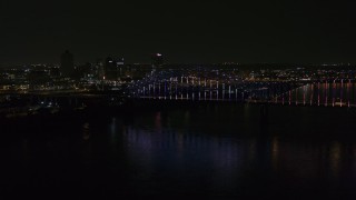 5.7K aerial stock footage of the skyline behind bridge with colorful lights at night, Downtown Memphis, Tennessee Aerial Stock Footage | DX0002_187_042