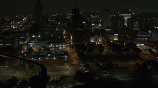 5.7K aerial stock footage fly away from Raymond James Tower and nearby buildings at nighttime, Downtown Memphis, Tennessee Aerial Stock Footage | DX0002_187_076