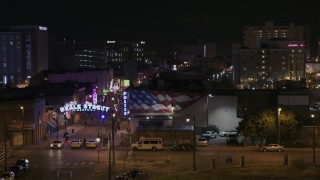 5.7K aerial stock footage reveal the Beale Street sign while descending by clubs and restaurants at nighttime, Downtown Memphis, Tennessee Aerial Stock Footage | DX0002_188_047