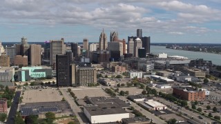 5.7K aerial stock footage the skyline behind office buildings, Downtown Detroit, Michigan Aerial Stock Footage | DX0002_189_026