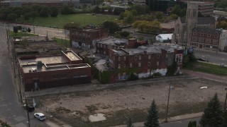 DX0002_192_017 - 5.7K aerial stock footage circling around an abandoned building at sunset, Detroit, Michigan