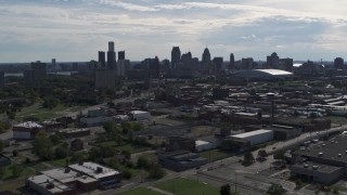 5.7K aerial stock footage of flying by the city's skyline, seen from brick industrial buildings, Downtown Detroit, Michigan Aerial Stock Footage | DX0002_195_021