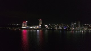 DX0002_199_001 - 5.7K aerial stock footage of a stationary view of Caesars Windsor hotel and casino across the river at nighttime, Windsor, Ontario, Canada