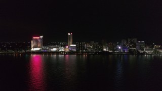 DX0002_199_002 - 5.7K aerial stock footage of orbiting Caesars Windsor hotel and casino across the river at nighttime, Windsor, Ontario, Canada